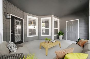 A living room with a grey couch, a wooden coffee table, and a grey wall.